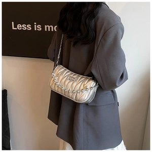Detail of silver quilted shoulder bag featuring metallic bead chain and pleated texture