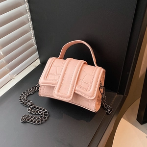 Pink mini crossbody bag with crocodile texture and metal chain strap on minimalist background