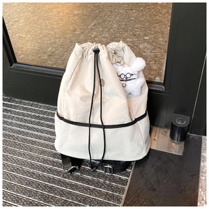 Details des beigen Nylon-Rucksacks mit Wabennetz und Plüschtier-Anhänger-Detail