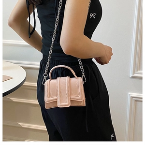 Detailed side view of mini light pink leather handbag with silver metal chain strap
