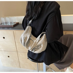 Detailed view of silver hobo bag with satin finish and elegant bow embellishments