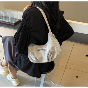 Detail of silver-grey pleated hobo bag featuring three delicate decorative bows on the front