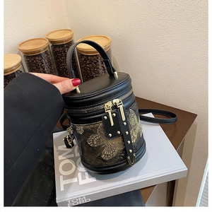 Detailansicht der goldenen Schmetterlingsstickerei auf der schwarzen Leder-Beuteltasche