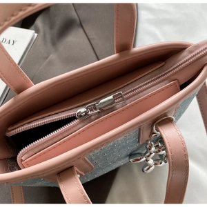 Close-up of pink leather tote bag with blue sequin fabric and silver balloon dog charm