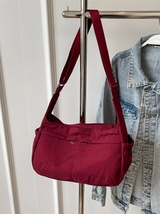 Large burgundy nylon crossbody bag with front zipper pockets and adjustable wide strap