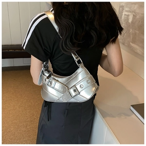 Detail view of silver Y2K punk style shoulder bag with metallic eyelets and buckle straps