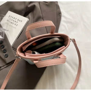 Internal view of mini bucket bag showing zipper compartment and storage for essentials