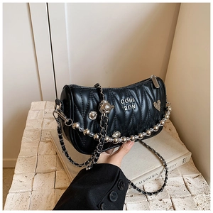 Close-up of black quilted chain bag with bead charms and silver hardware details