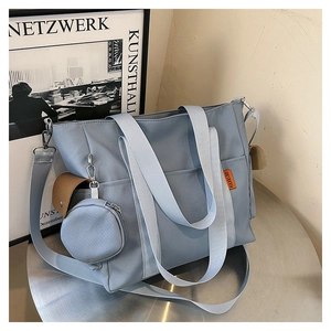 Detail of blue canvas tote bag featuring removable coin purse and adjustable strap