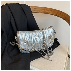 Detail of silver quilted crossbody bag with metallic chain strap and embossed logo