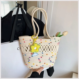 Détail du sac cabas tissé avec pois arc-en-ciel et pendentif fleur jaune souple