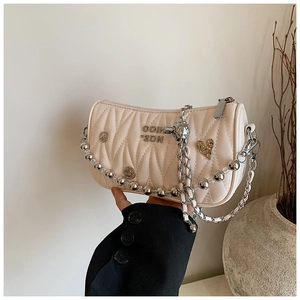 Detail of beige pleated crossbody bag featuring heart charms and stylish double chains