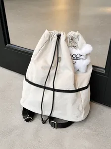Mochila minimalista de nailon beige con cierre de cordón y colgante de cachorro de felpa