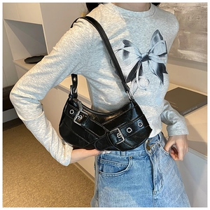 Detail of black motorcycle style underarm bag with silver buckles and eyelets on shoulder