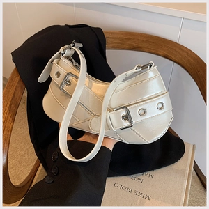 Detail of white glossy crescent shoulder bag with metallic eyelets and belt buckle accents