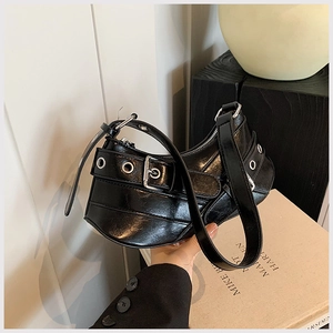 Close-up of black leather crescent underarm bag with silver metal eyelets and buckles