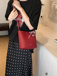 Red bucket bag for women with pearl bow and gold heart pendant on a shoulder strap