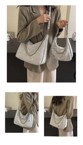 Detail view of large and small grey hobo bags with metallic butterfly and chain