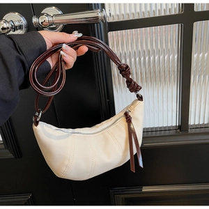 Detail of canvas crescent bag with leather knotted strap and contrast stitching