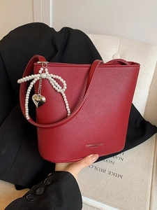 Minimalist red pebble leather bucket bag with pearl bow and silver heart pendant