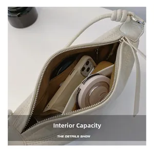 Internal view of off-white dumpling bag showing spacious capacity for phone and cosmetics