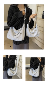 Detail view of silver Hobo bag with metallic butterflies in large and small sizes