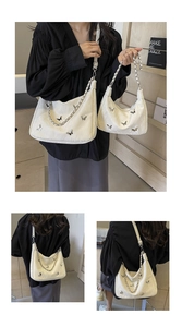 Detail view of white soft PU shoulder bags featuring silver butterfly buckles and chains