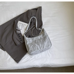 Detail of silver pleated texture hobo bag with chunky chain and adjustable strap