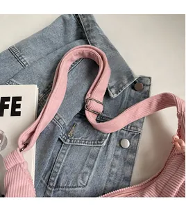 Detailed view of pink corduroy crossbody bag with smooth adjustable shoulder strap