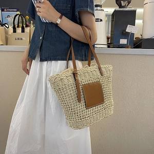 Handwoven straw tote bag with brown leather handles and drawstring lining for women