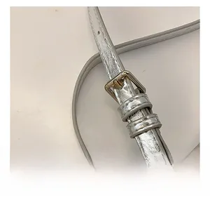 Detail of adjustable silver shoulder strap with metallic finish and metal buckle