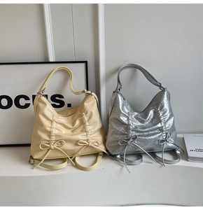 Dettaglio di borse a tracolla increspate con decorazione a fiocco in beige e argento