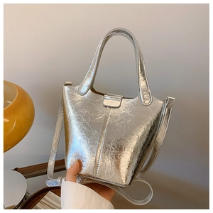 Detail of silver metallic bucket bag with textured finish and versatile crossbody strap