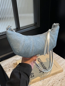 Light blue denim croissant shoulder bag with silver leather strap and curved stitching