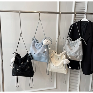 Gedetailleerde weergave van bucket backpacks in vier kleuren met vlinders en kettingbanden