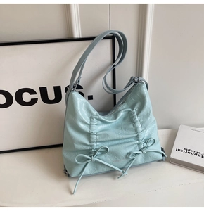 Dettaglio della texture in pelle PU azzurra con fiocchi decorativi e logo MOROMORO