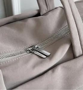 Detalle de cremalleras metálicas suaves y tejido de nailon en el bolso bandolera