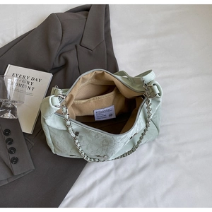 Macro shot of mint green tote bag interior with zipper pocket and metal chain details