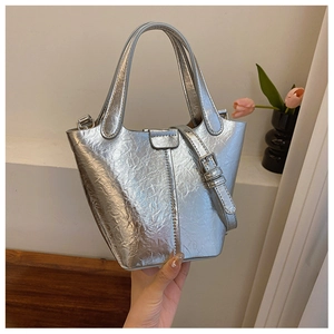 Detail of silver metallic bucket bag showing textured finish and adjustable shoulder strap