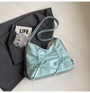 Dettaglio della borsa tote azzurra in pelle PU stropicciata con eleganti fiocchi