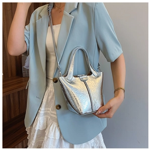 Detail of silver pleated bucket bag with metallic texture and adjustable shoulder strap