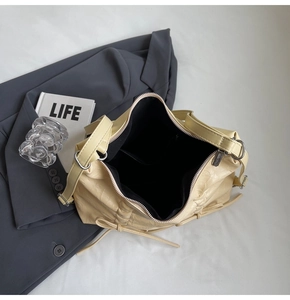 Dettaglio della borsa tote beige con pieghe laterali alla moda e chiusura a zip liscia