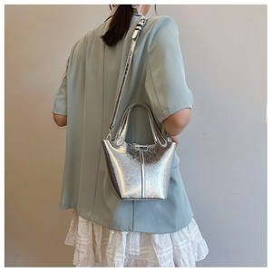 Detail of silver metallic bucket bag showing cracked texture and adjustable strap hooks