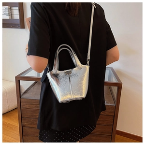 Detail of silver metallic bucket bag with pleated texture and adjustable strap
