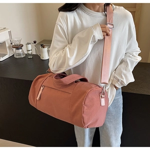 Detalle del bolso rosa con correa de hombro extraíble y asa resistente