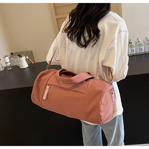 Vista de estilo de vida de bolsa de viaje rosa palo con correa ajustable al hombro