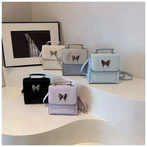 Vue détaillée de cinq mini sacs à main colorés avec boucles papillon sur marches
