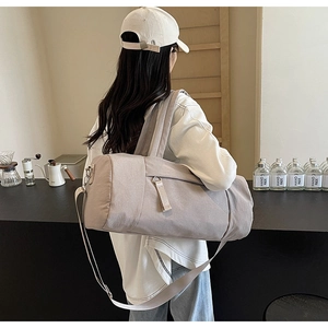 Primer plano del bolso de viaje con asas resistentes y correa de hombro ajustable gris