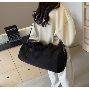 Detalle del bolso de viaje grande de nailon negro con hebillas plateadas y bandolera
