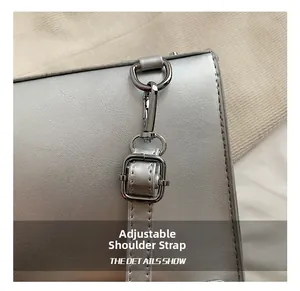 Détail du fermoir mousqueton argenté et de la boucle réglable sur un sac à dos chic